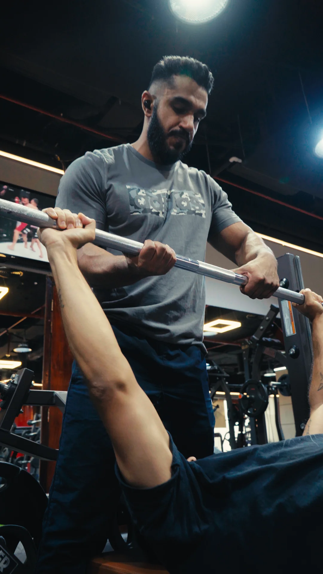 Shravan guiding a client through a strength exercise
